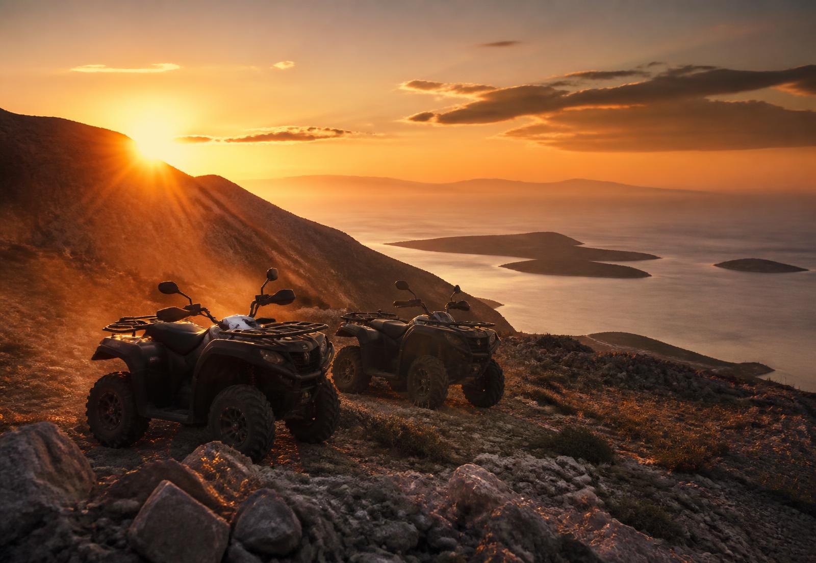 Two quad bikes parked on a mountain ridge above the Adriatic sea near Split at sunset